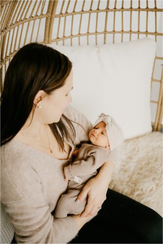 infant baby looking at mom holding her